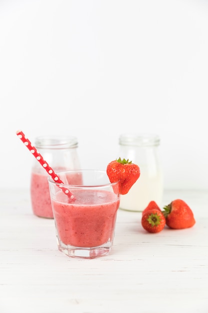 Free photo close up strawberry smoothie glasses on table