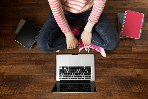 Free photo close up student on floor with laptop