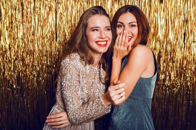 Close up studio image of two amazing sexy celebrating girls  with red lips,