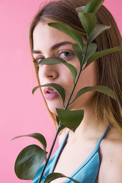 Free photo close up of stylish girl and palm tree leaves