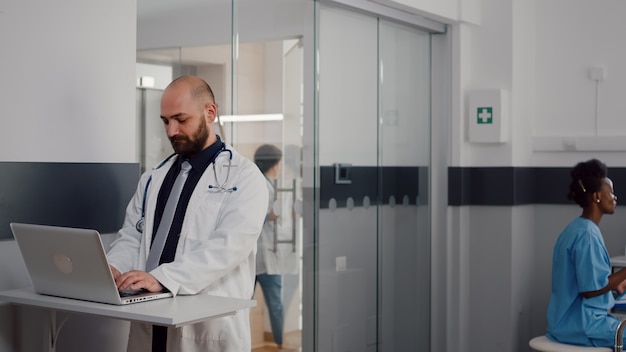 Free photo close up of surgeon doctor wearing medical uniform typing recovery treatment