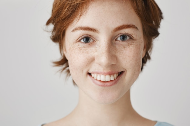 Close-up of surprised and excited smiling redhead girl