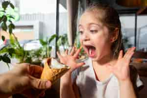 Free photo close up surprised girl with ice cream