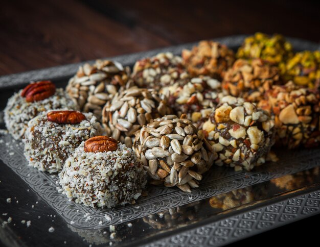 Close-up sweets handmade handmade sweets from nuts, dried fruits and honey on a dark wooden table horizontal