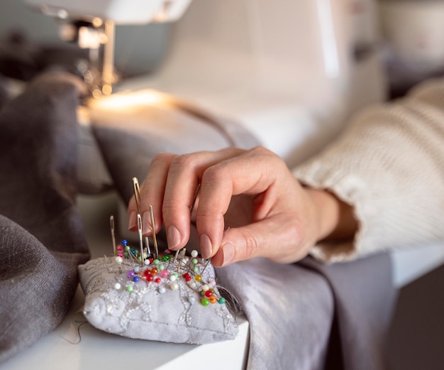 Free Photo close-up tailor hands working with needles