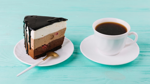 Close-up of a tasty creamy pie with spoon and cup of tea