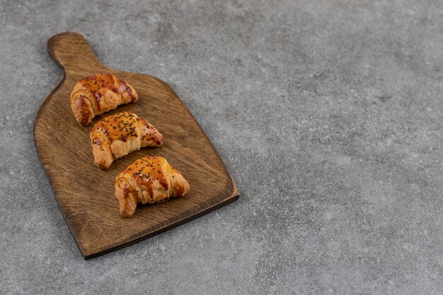 Close up of tasty homemade cookies on wooden cutting board over grey surface