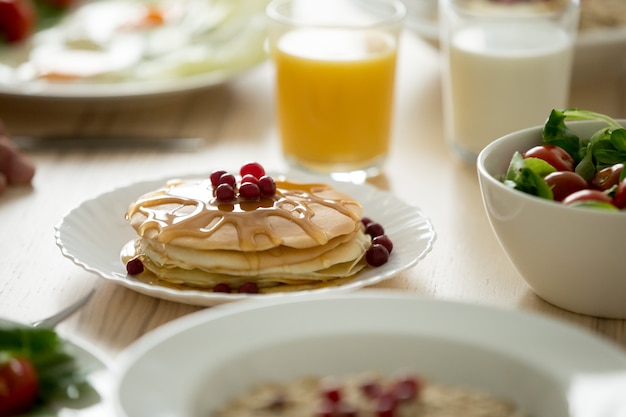 Close up of tasty pancakes served with syrup and berries