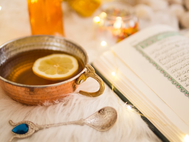 Free photo close up tea next to opened  quran