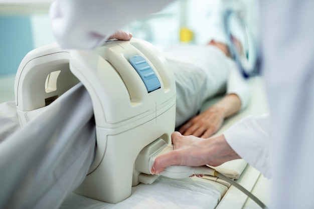 Free photo close up of technician preparing a patient for knee mri scan procedure at clinic