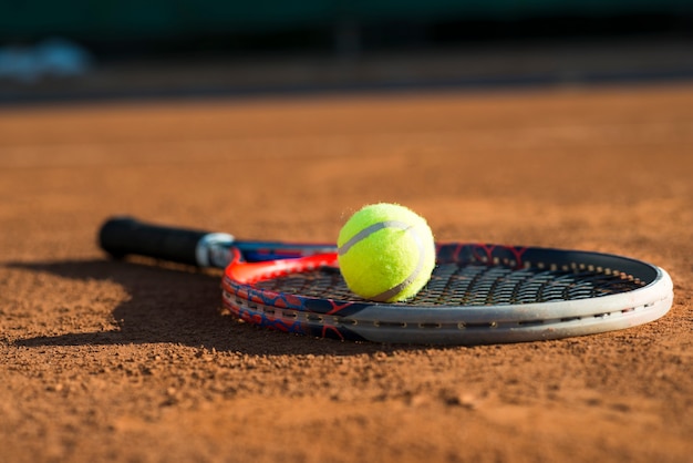 close-up tennis ball on a racket placed on the floor