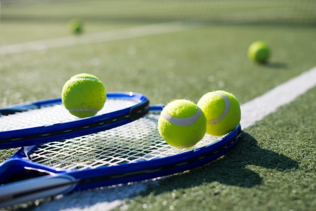 Close-up tennis rackets and balls on the ground