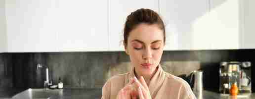 Free photo close up of thinking woman in kitchen wearing bathrobe standing thoughtful and making dinner cooking