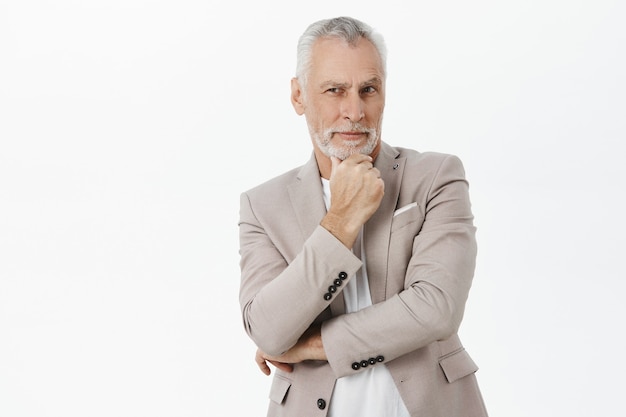 Close-up of thoughtful handsome old man looking, pondering decision, choosing