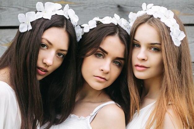 Close-up of three attractive teens with floral wreaths