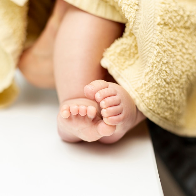 Free photo close-up tiny baby feet with towel