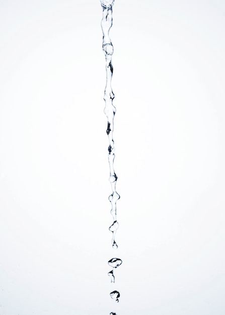 Close-up transparent liquid flowing on light background