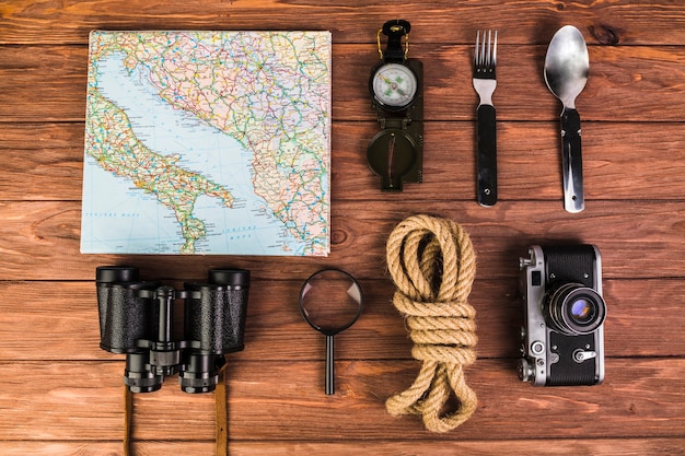 Free photo close-up of traveler's equipments arranged on wooden table