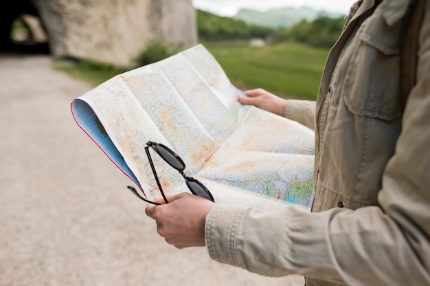 Free Photo close-up traveller holding map and sunglasses