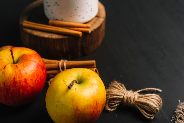 Free photo close-up tread and apples near cinnamon and mug