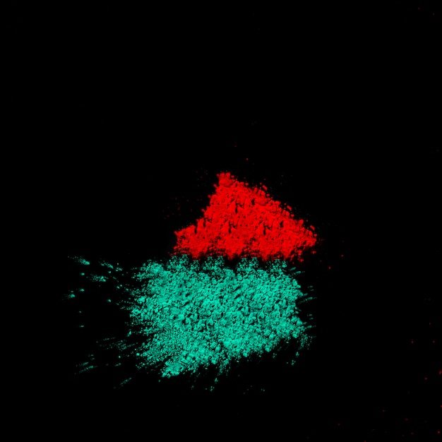 Free photo close-up of turquoise and red powder on black backdrop