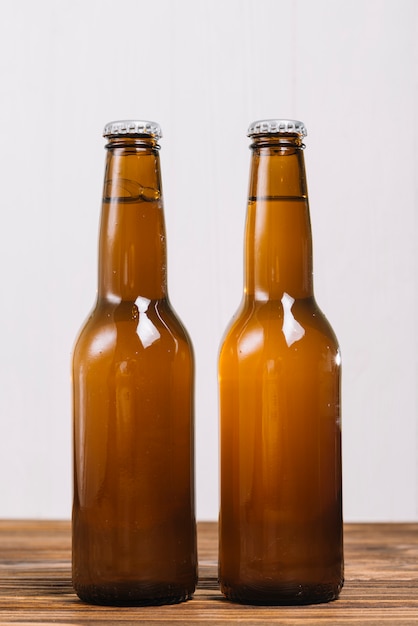 Free photo close-up of two beer bottles on wooden surface