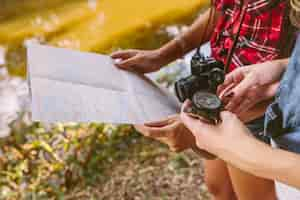 Free photo close-up of two female friend holding compass and map