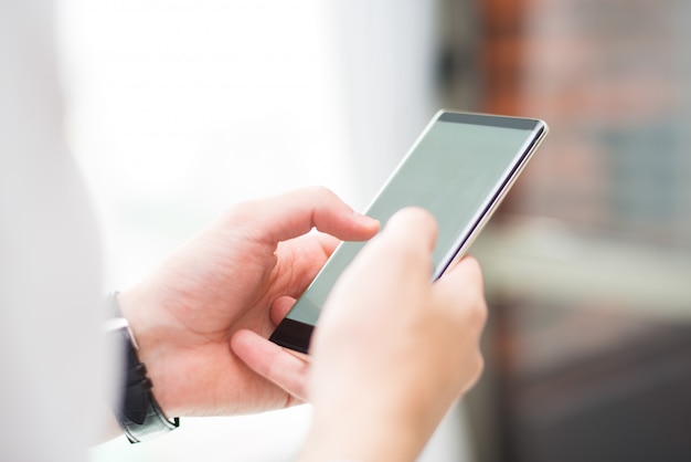 Free photo close-up of unrecognizable man touching smartphone screen