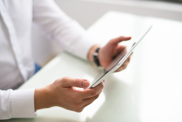 Free photo close-up of unrecognizable man watching video on tablet