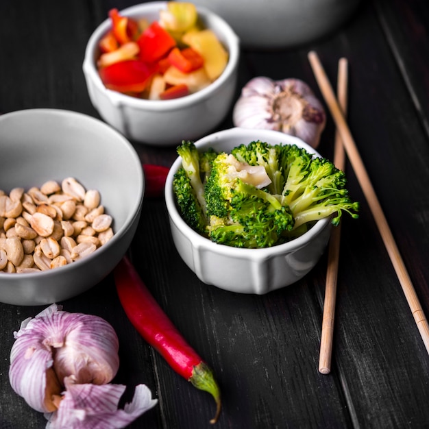 Close-up of vegetables in cups with garlic and chopsticks