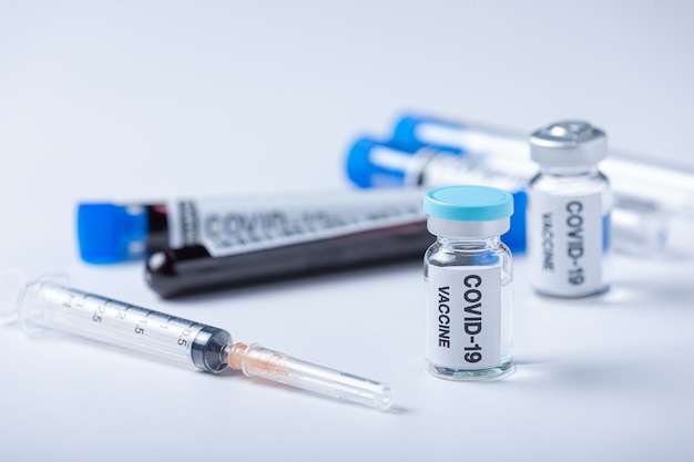 Close up a vial of covid-19 vaccine in hand of a scientist or doctor