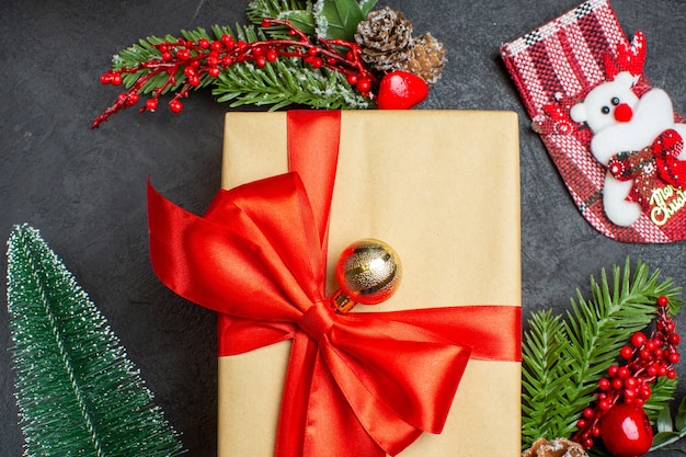 Close up view of Christmas mood with beautiful gifts with bow-shaped ribbon and fir branches decoration accessories xsmas sock on a dark background