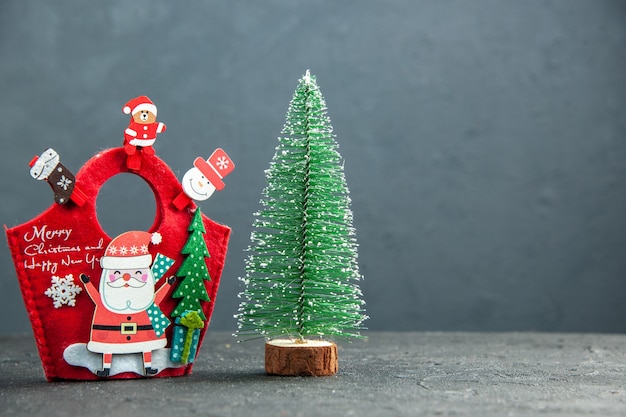 Close up view of christmas mood with decoration accessories on new year gift box and xsmas tree on the right side on dark surface