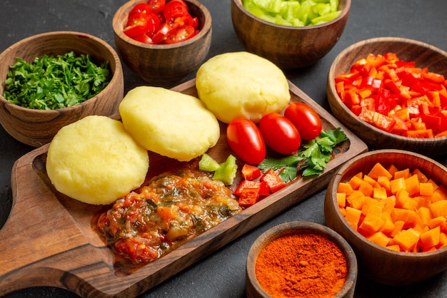 Close up view of cooking with fresh vegetables and chopped foods on the black table