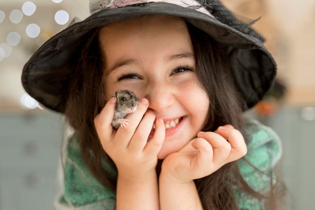 Free photo close-up view of cute little girl holding a hamster