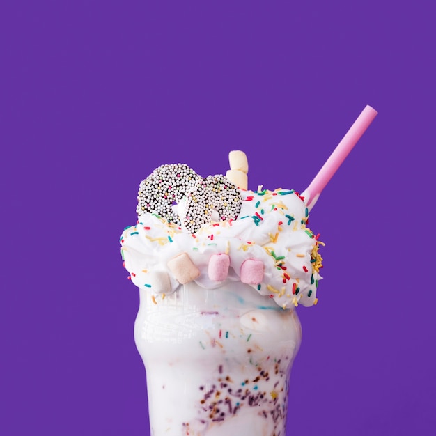 Free photo close-up view of delicious milkshake on purple background