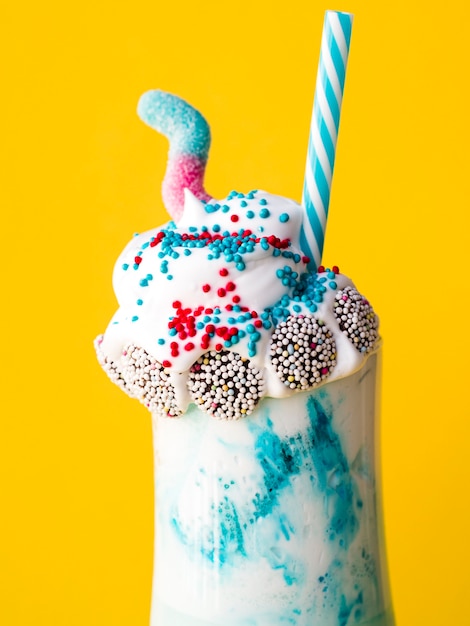 Free photo close-up view of delicious milkshake with yellow background