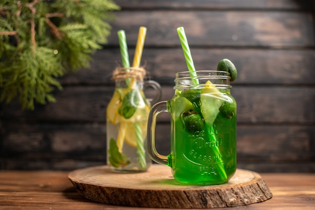 Close up view of detox water and fresh juice on brown wooden background