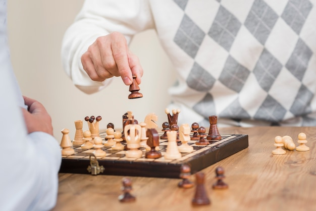 Free Photo close-up view of father hand and chess board on table