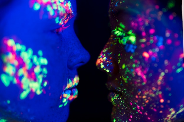 Free Photo close-up view of fluorescent make-up on people's face