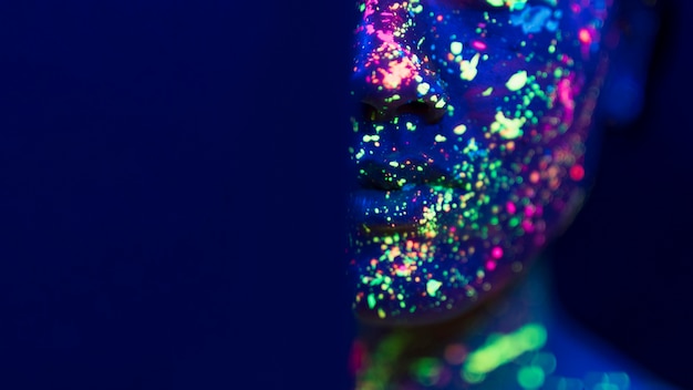 Free photo close-up view of fluorescent make-up on person face