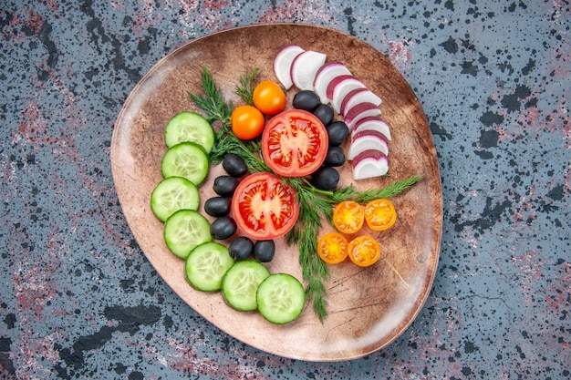 Free photo close up view of fresh chopped vegetables in a brown plate on mixed colors background