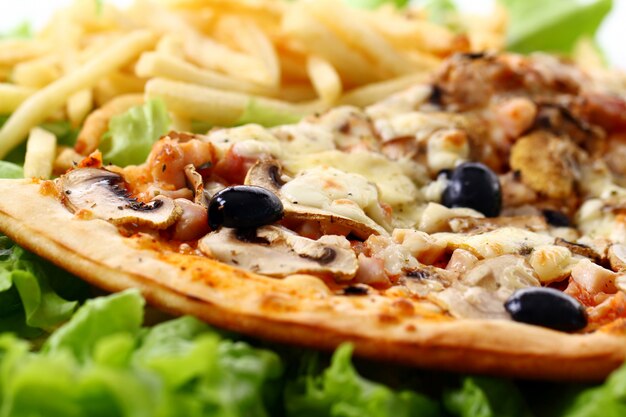 Close up view of fresh pizza with french fries