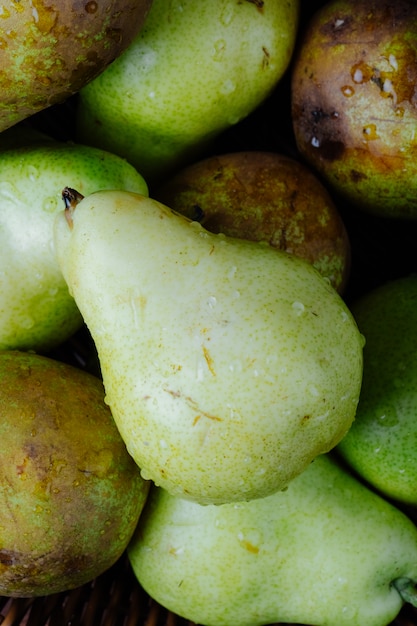 Close up view of fresh ripe pears with water drops in a wicker basket