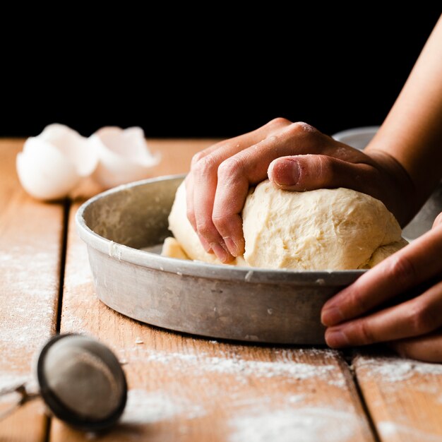 Close-up view of a hand making dough