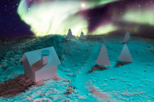 Close-up view of house on snow with aurora borealis