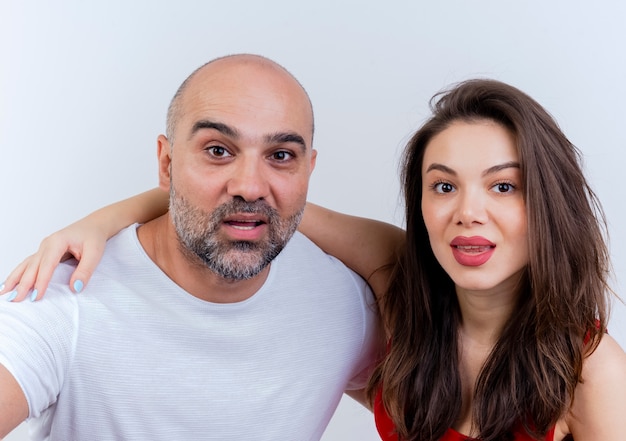 Close-up view of impressed adult couple woman putting hand on man's shoulder both looking 