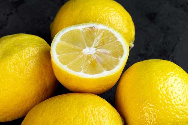 Close up view of lemons and a half on black