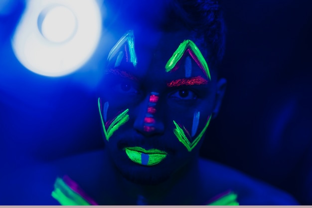 Close-up view of man wearing fluorescent make-up