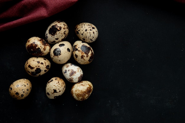 Close-up view of mini eggs on left side and black background with copy space